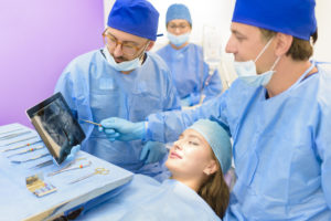 Woman about to undergo dental implant surgery looking at 3D image screen